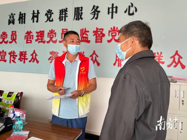 正在為群眾辦事的沈家江（左）。